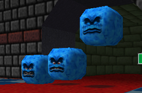 Three thwomps in Mario 64. They are lined up side by side and showcase gradually deepening stages of anger.