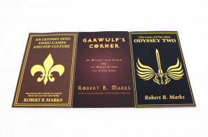 Three books in ochre, burgundy, and black - all embossed with gold foil. All three are by author Robert B Marks.