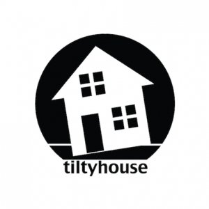 Tiltyhouse Media logo: a black circle on a white background. Inside the circle is the white silhouette of a house tilted at an angle that intersects the straight line of the ground.
