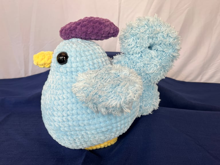 A side profile view of the blue chicken. Highlights the curled tail shape.