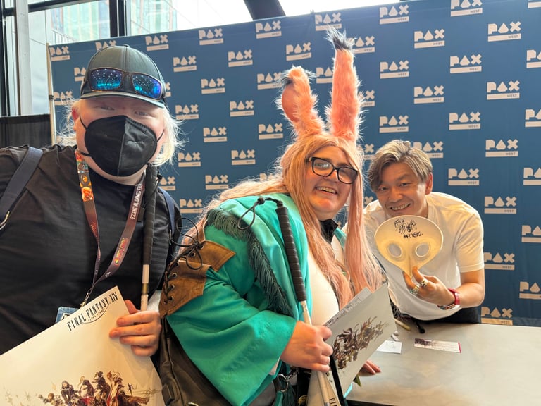 A photo of Mister Yoshi Sanpo (Naoki Yoshida, director of Final Fantasy 14) himself holding up the signed mask at Pax West. Myself and a blind friend are squeezed into the corner (myself in my own hand designed and hand made Taapu cosplay) but we're not what you should care about here :D