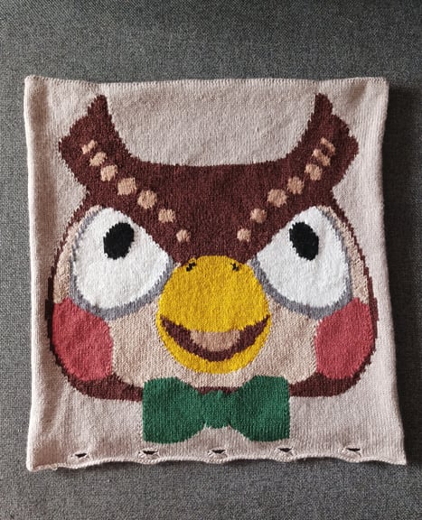A photo of the cushion cover on the Blathers side without the cushion insert, placed on a grey background.