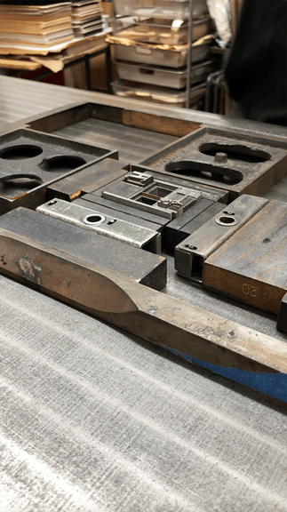The form & chase of handset type used to print the pips and ranks on each face. Every letter and space is a separate piece—to print each card face, the form is partially disassembled to swap out the ranks and suits, and re-locked into place.