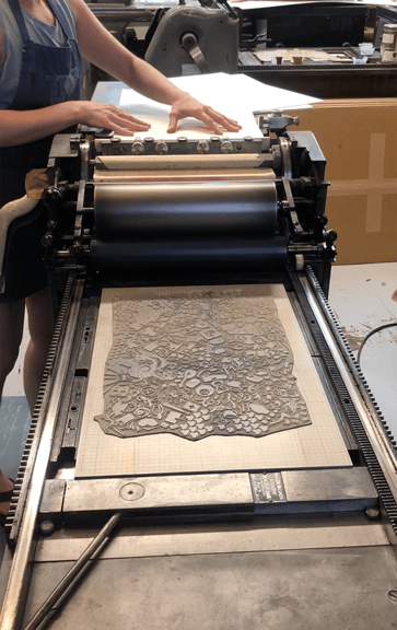 The flatbed press used to print the large linoleum block.