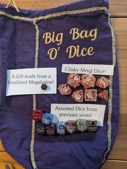 We have a selection of commemorative d6s from conventions past, Have I been working on this in the background for year? Maybe. 
We also have a shiny metal set of dice that go clinky-clinky and just sound wonderful when rolled!
And in terms of the truly exotic, I have found a d20 made from a fossilized megalodon shark! 