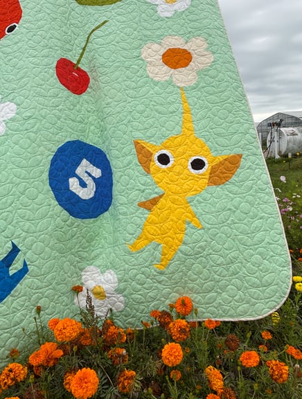 A close up of the corner with the yellow Pikmin and the blue posy pellet with some nice orange marigolds in front of it.