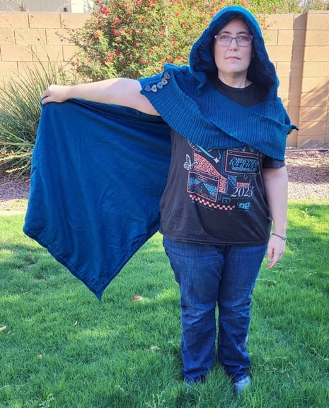5'5" (165 cm) tall person from the front wearing a dark blue cape with hood holding the side of the cape out to the side.  The cape is inspired from Legend of Zelda: Echoes of Wisdom.