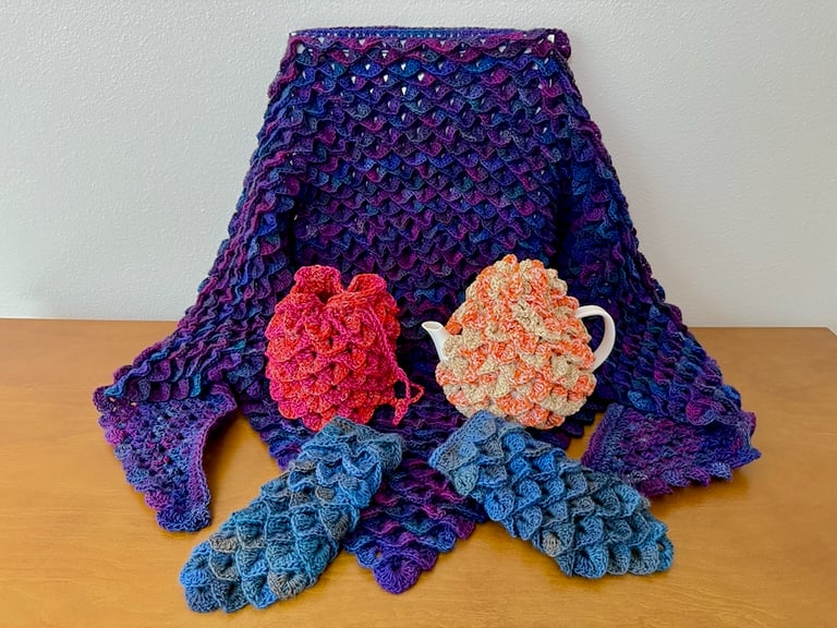 All four shift items: Shawl, dice bag, tea cozy, and fingerless gloves