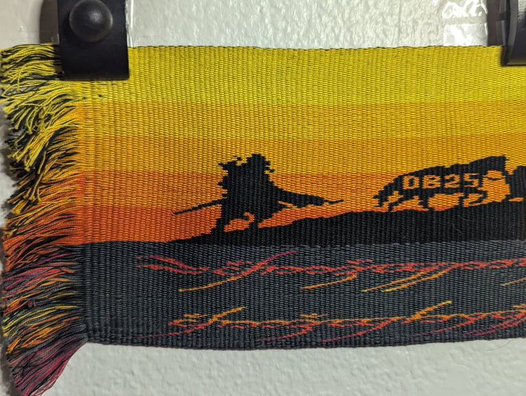 First of six close ups of a tapestry starting from the left side depicting Aragorn & Sam leading Bill the pony with the text “DB 25” on him above part of the One Ring’s inscription.