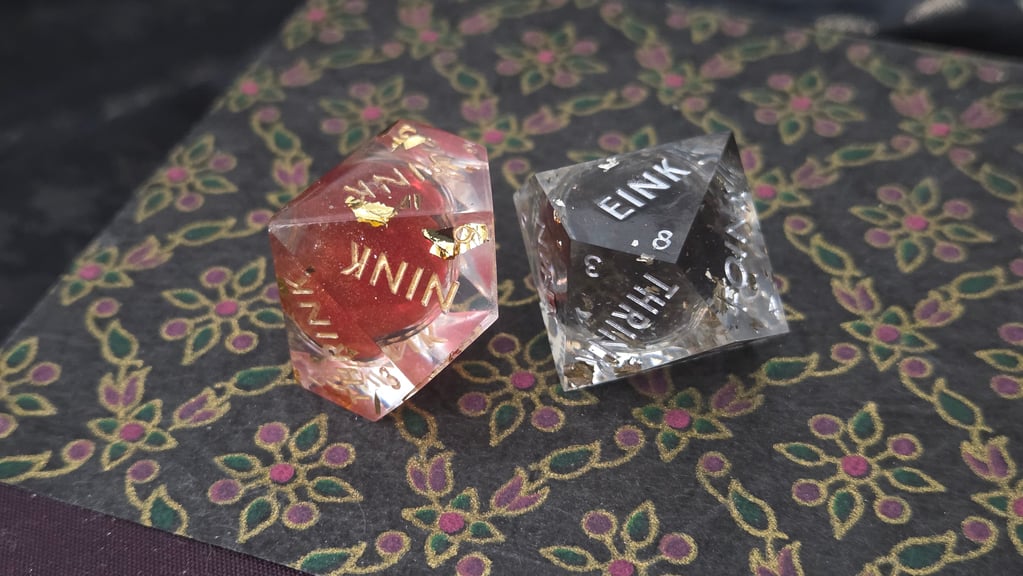 Two d10 liquid core dice featuring red and gold glitter and sparkle glitter on black.  For best results, shake your liquid core dice before rolling.
