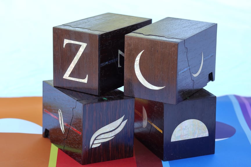 All four boxes, this time stacked with the tops pointing toward the camera. The subtle patterns of the mother-of-pearl inlays are clearly visible.